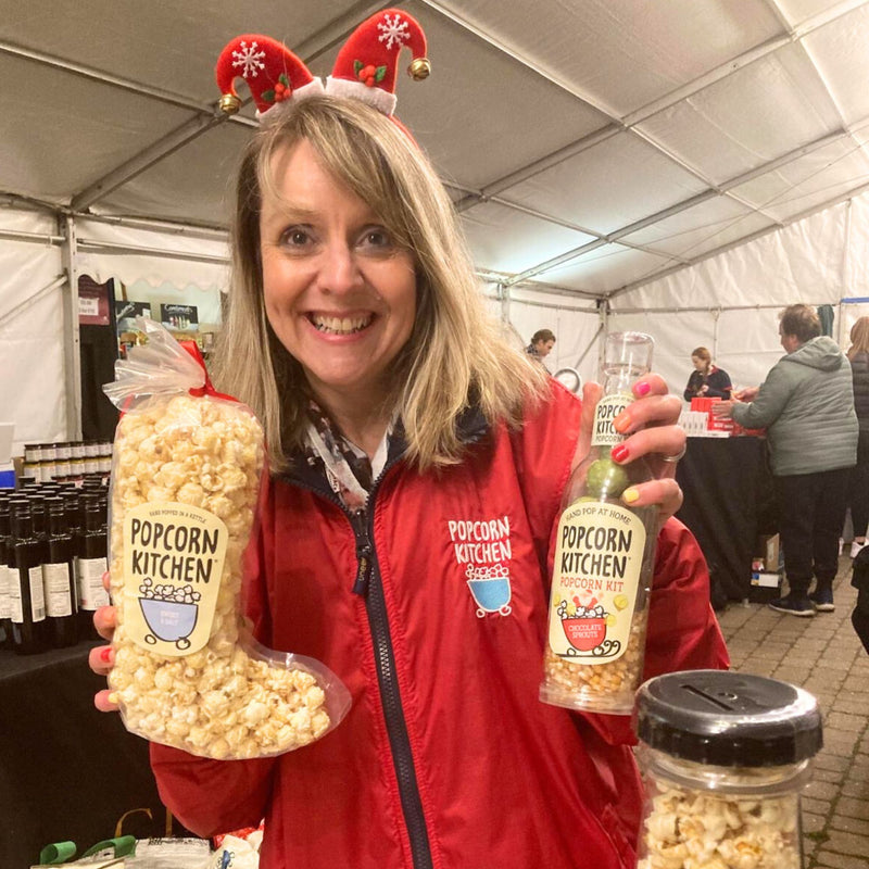 Louise holding a popcorn stocking and popcorn bottle at an event