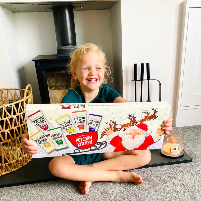 Young girl holding a Christmas Treat Popcorn Selection Box 